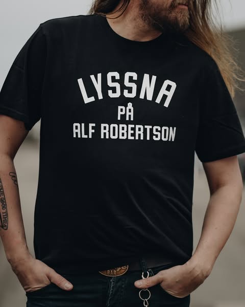 ”Lyssna på Alf Robertson” på t-shirt.
